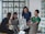A group of professionals collaborating around a table with laptops.