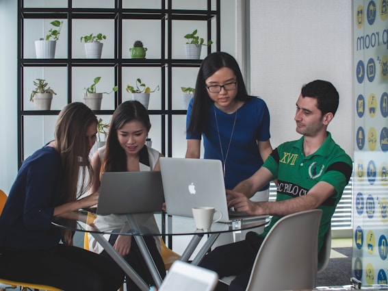 A diverse team collaborating around a table with charts and laptops, symbolizing business transformation.