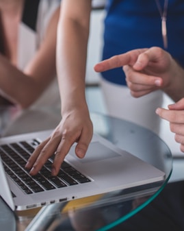 person touching and pointing MacBook Pro