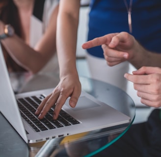 person touching and pointing MacBook Pro