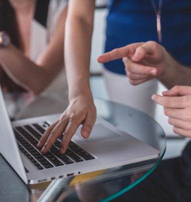 person touching and pointing MacBook Pro