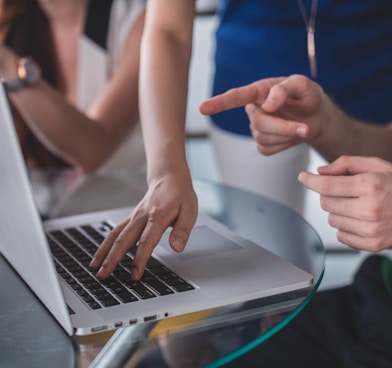 person touching and pointing MacBook Pro