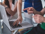 person touching and pointing MacBook Pro
