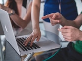 person touching and pointing MacBook Pro