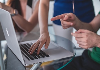 person touching and pointing MacBook Pro