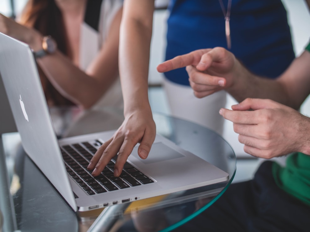 person touching and pointing MacBook Pro