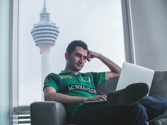 A relaxed homeowner reviewing real estate options on a laptop at home.