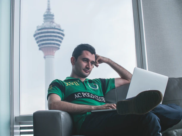A thoughtful man reading a blog on his laptop in a cozy home setting.