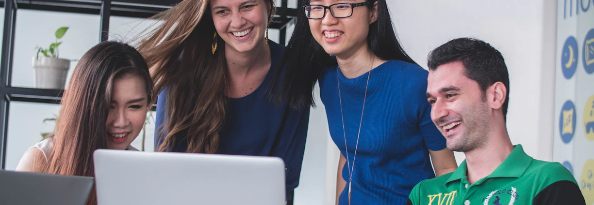 A friendly team gathered around a laptop in a modern office at 4134 Barlow St, Cottleville.