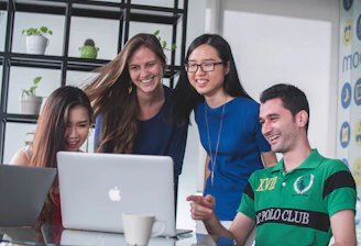 A friendly team gathered around a laptop in a modern office at 4134 Barlow St, Cottleville.