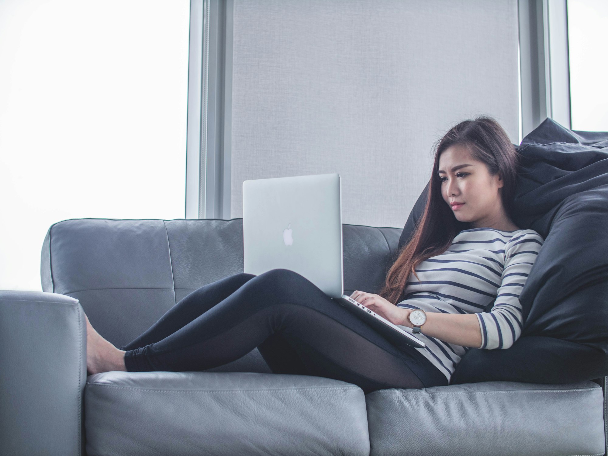 Womean working from home on sofa with laptop