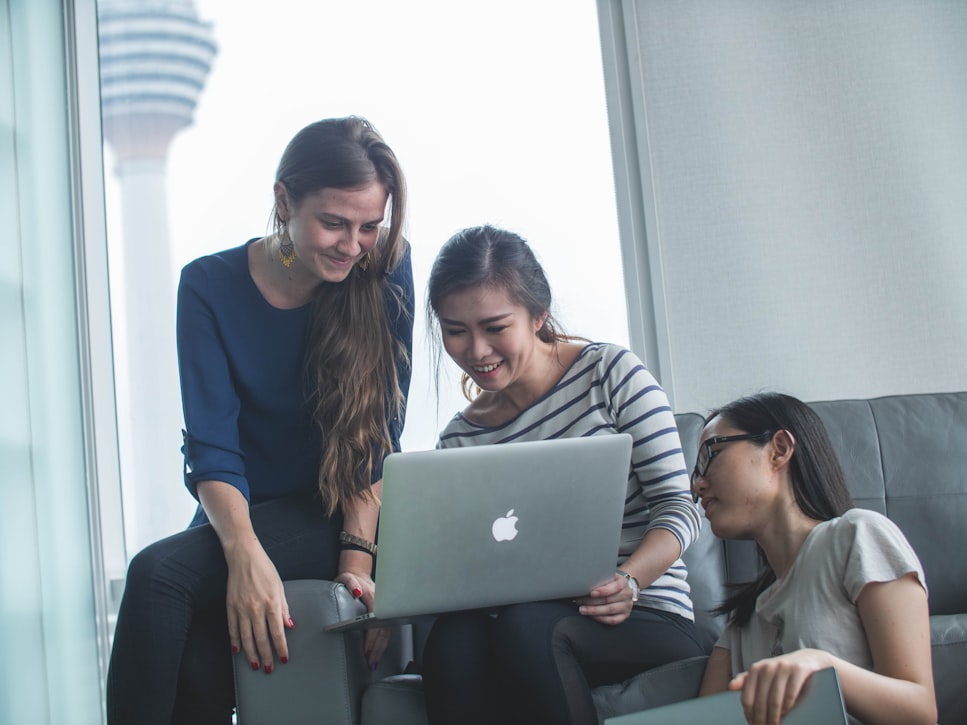 3 women looking at a laptop