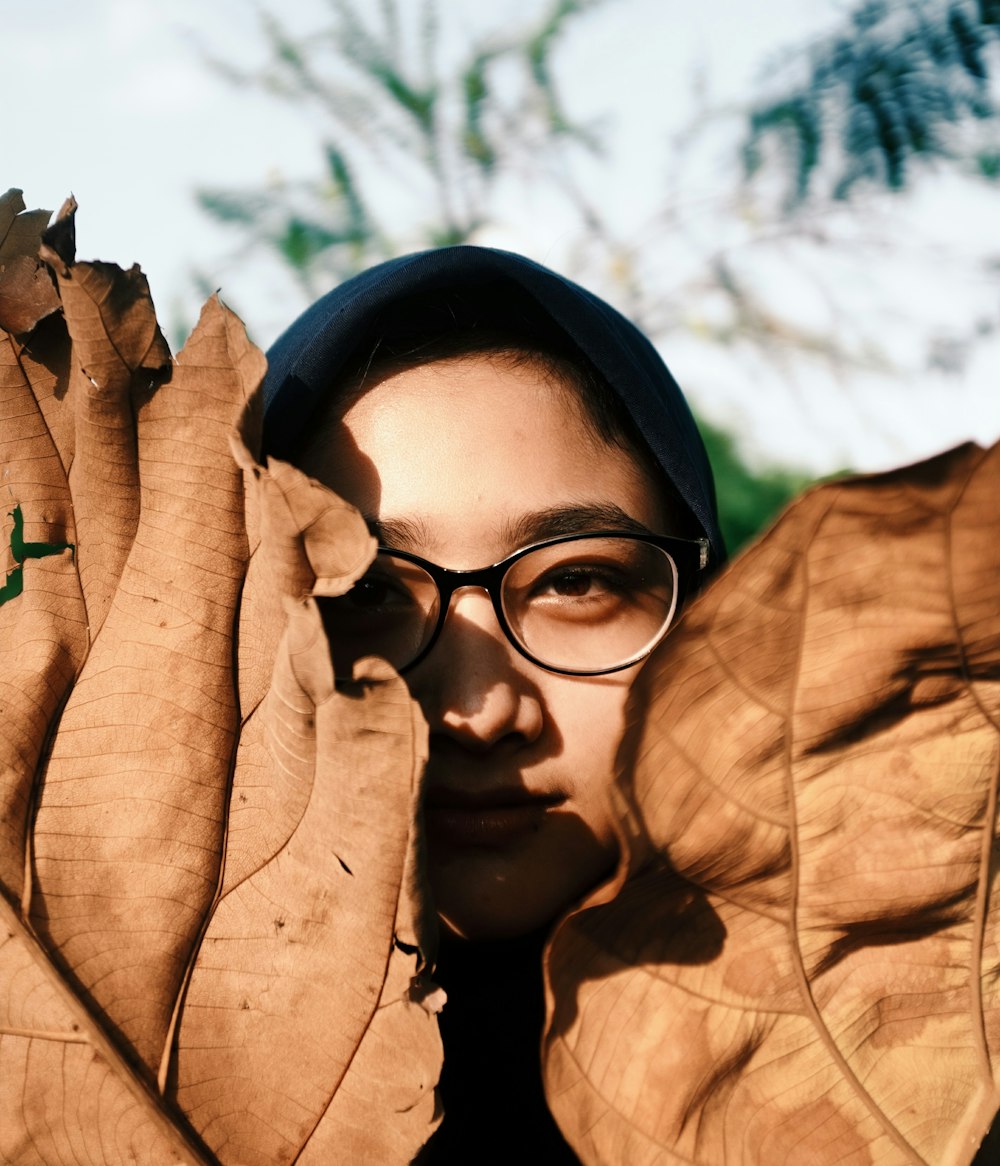 person hiding in brown leafed decors