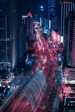 A nighttime cityscape of Tunisian streets glowing under red and black neon lights.