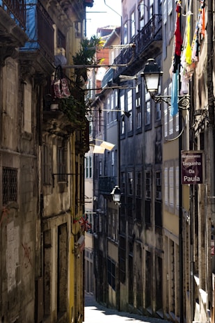 A grainy analog photo of an old European alley bathed in soft morning light.