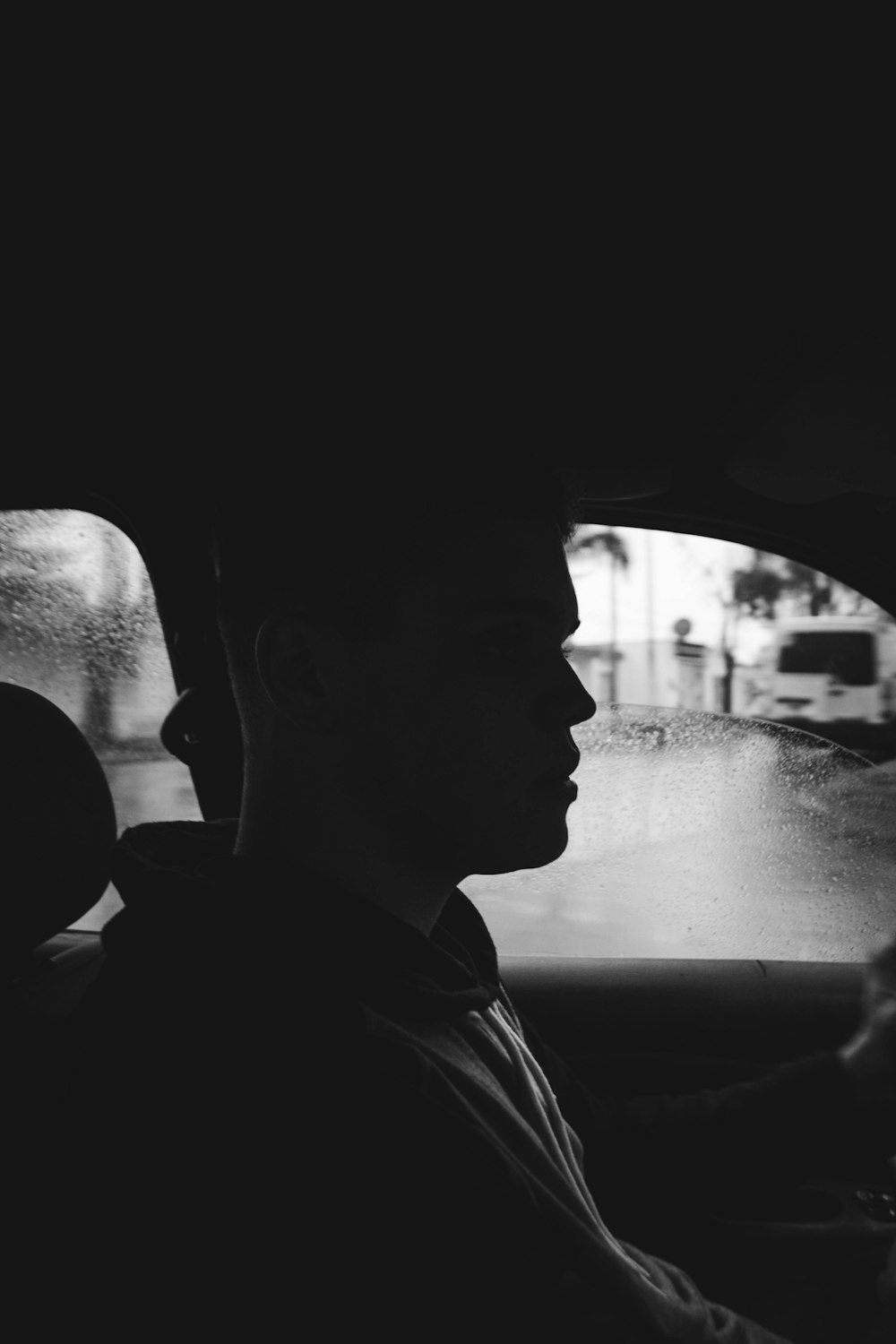 grayscale photography of man inside car