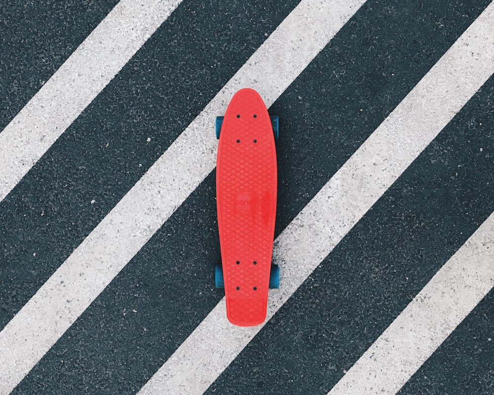 red cruiserboard on gray and white pedestrian lane