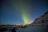 Northern lights dancing over a snowy forest with a group of excited hikers admiring the sky.