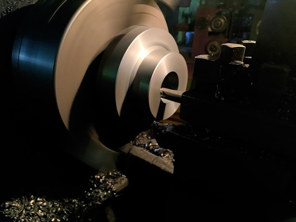 Close-up of a skilled technician operating a lathe machine in a bright workshop.