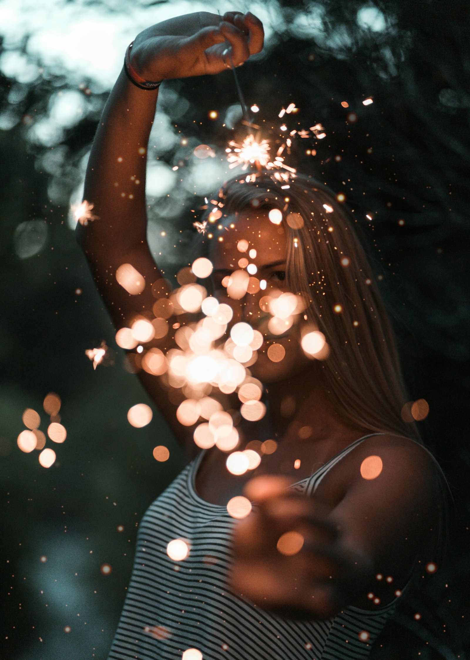 Sony a7 + Sony FE 85mm F1.8 sample photo. Woman holding sparklers bokeh photography