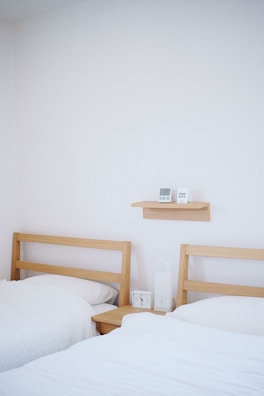 Minimalist bedroom furniture display with bed frame and bedside tables.