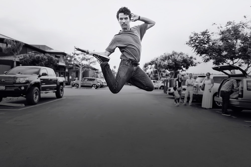 grayscale jumping photo of man