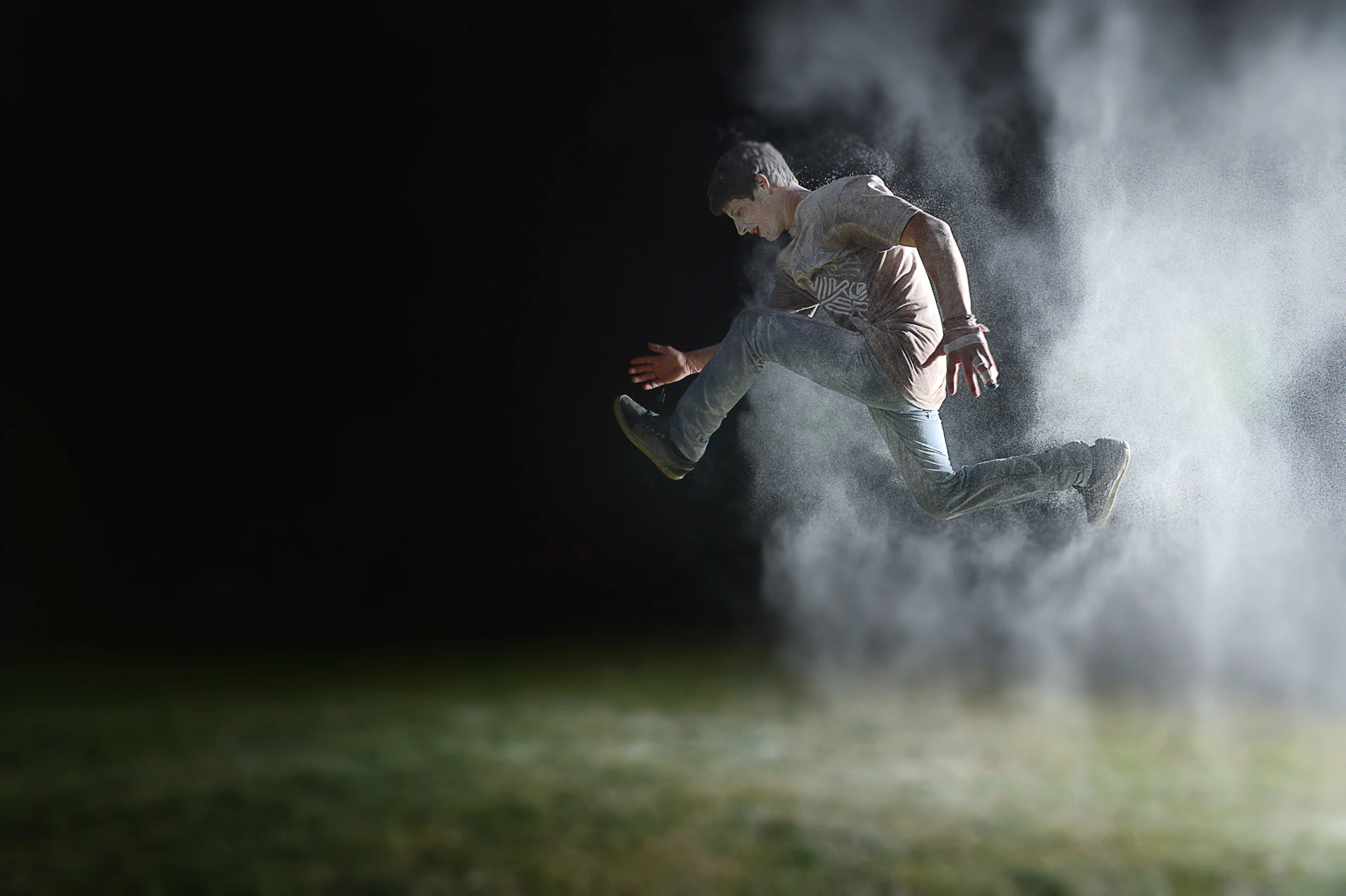 Jerry T. Adams on set, mid-action, captured in a dynamic leap with crew and equipment blurred in the background.