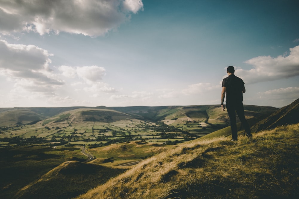 person standing on hill during cloudy daytime