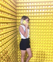 A friendly customer service representative answering calls in a yellow and black themed office.