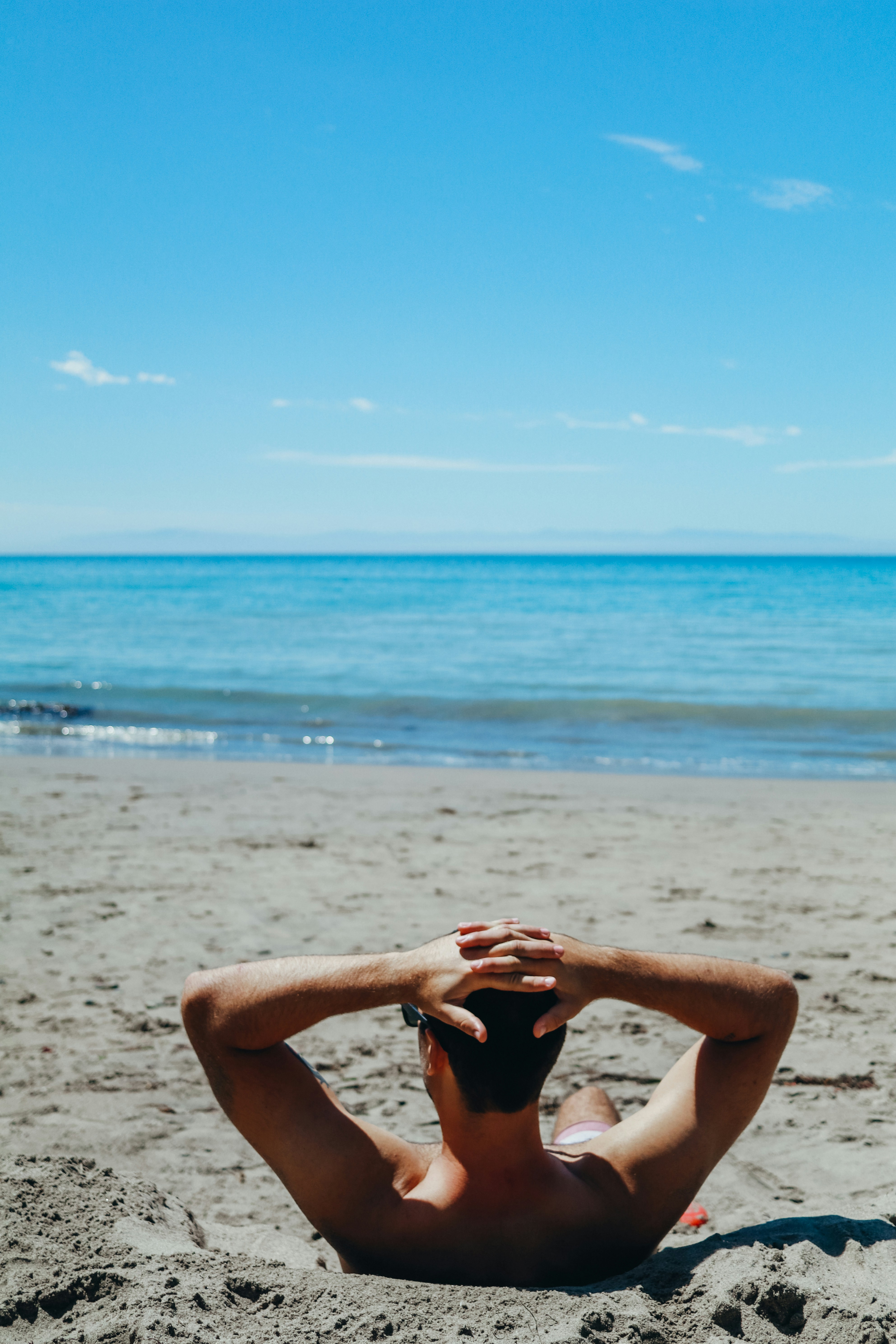 man leaning on beach