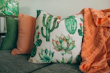 three green, orange, and white throw pillows on sofa
