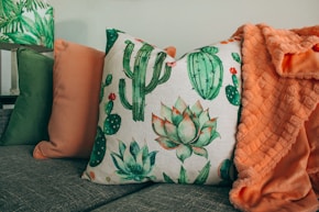 three green, orange, and white throw pillows on sofa