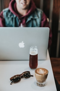 A confident business owner reviewing trademark documents with a laptop and coffee nearby.