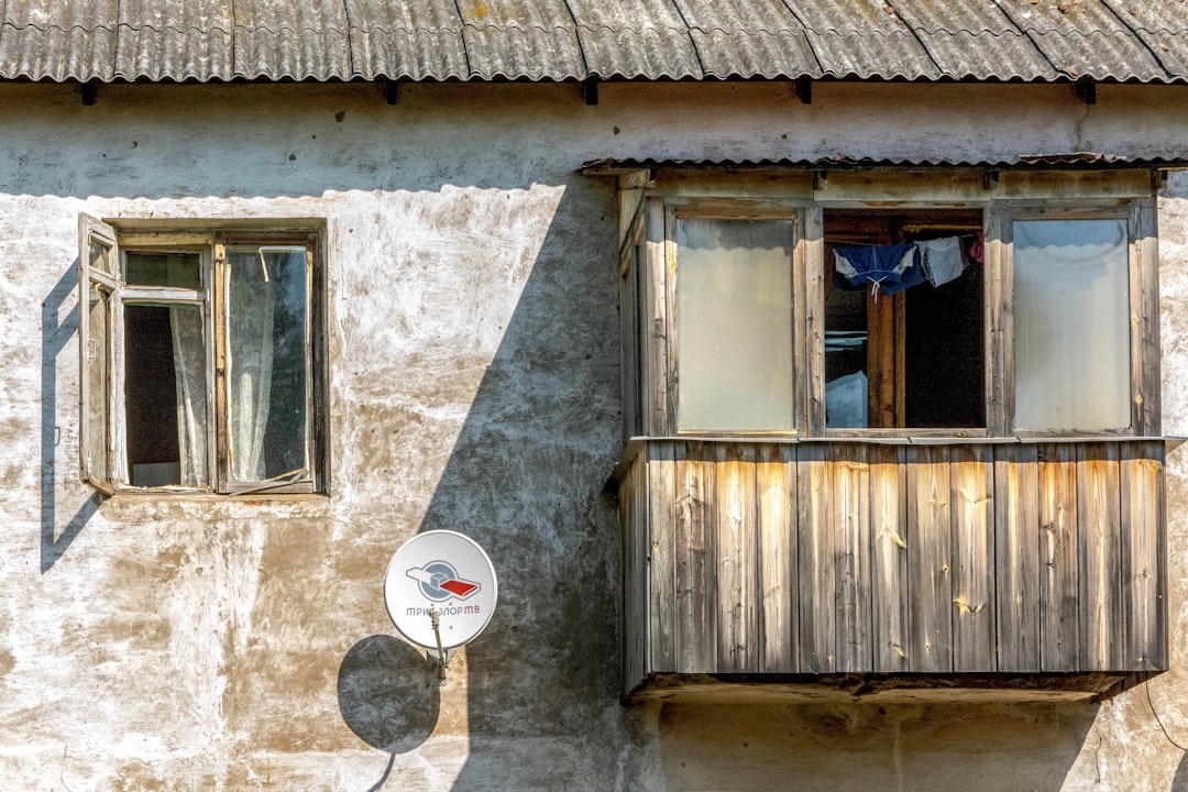 white parabolic antenna mounted on the wall of house