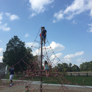 Children enjoying recess on the spacious playground under a clear blue sky.