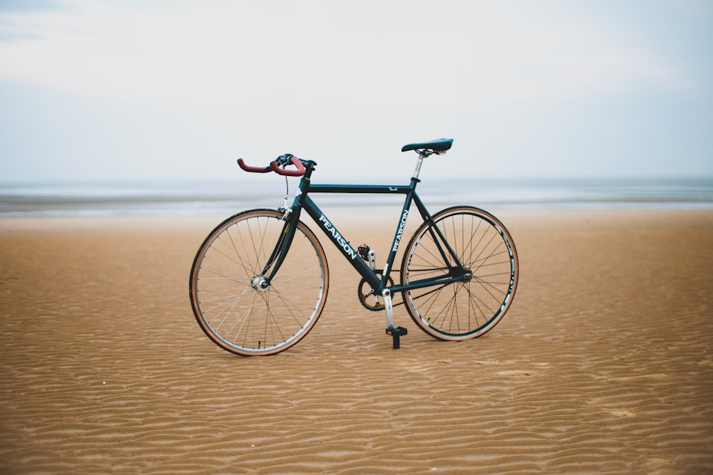 Bicicleta de carretera negra sobre arena