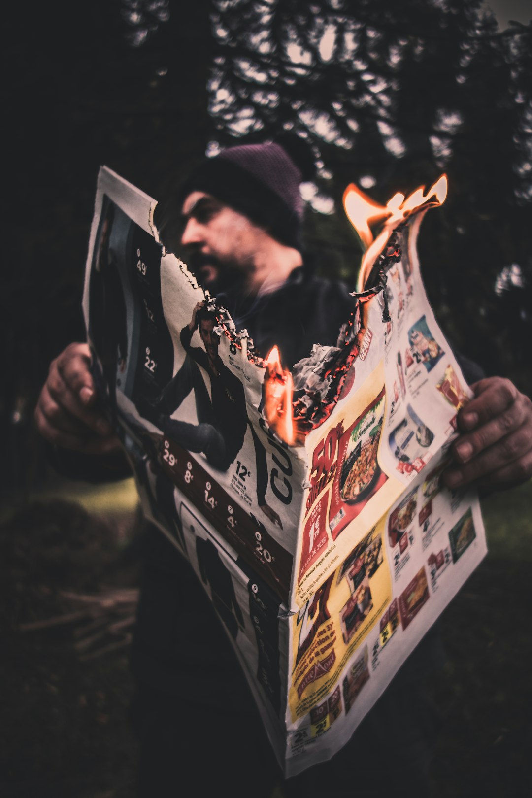 person holding firing newspaper