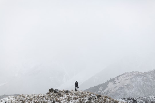 man standing on hill in Mount Cook New Zealand