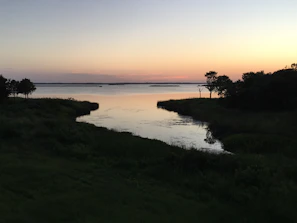 A peaceful lakeside at sunset with reflections of the sky, evoking calm and reflection