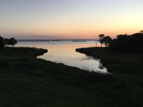 A tranquil lake at dusk, reflecting soft colors and inspiring a sense of stillness.