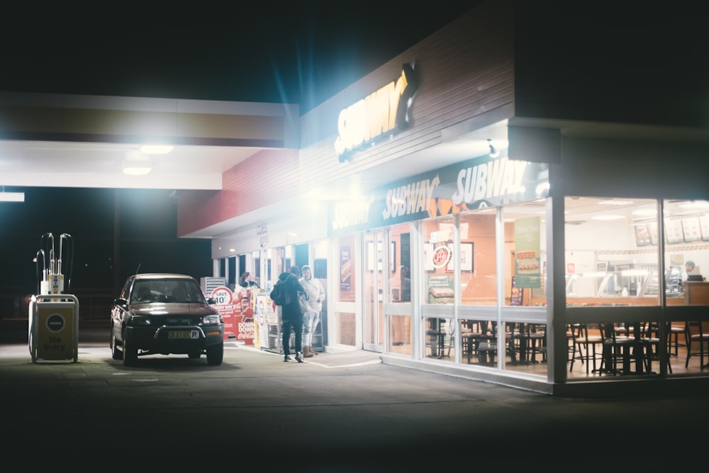 black car beside two men during night time