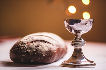 gray footed cup beside baguette bread