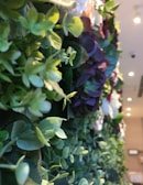 Close-up of delicate blooms and greenery artfully arranged on a modern event backdrop.