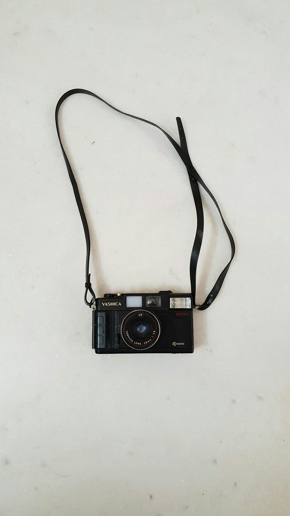 흰색 표면에 검은 Yashica 다리 카메라