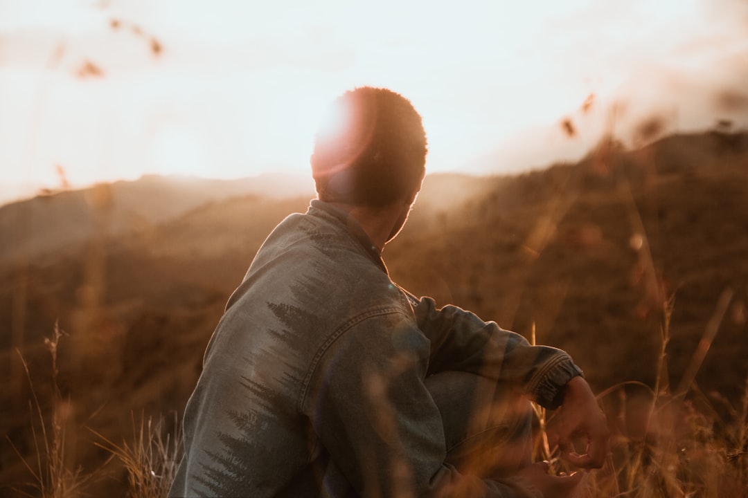 person sitting on brown grass during daytime