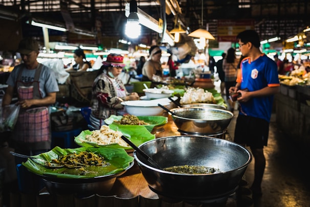 A group sharing a traditional Thai meal in a bustling Phuket market, smiles and colorful dishes all around.