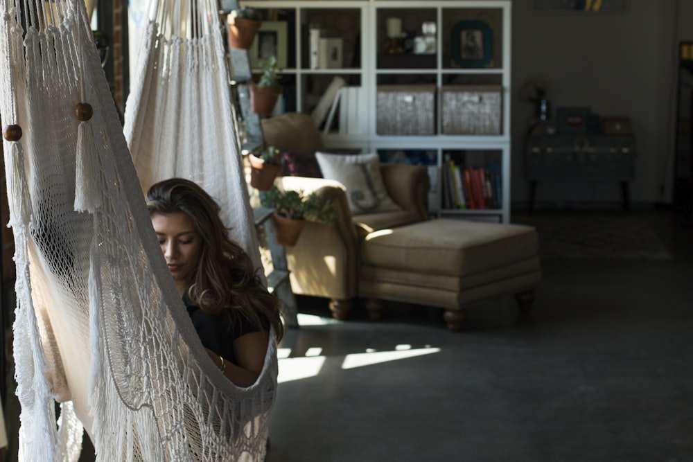 woman on white knit hammock during daytime