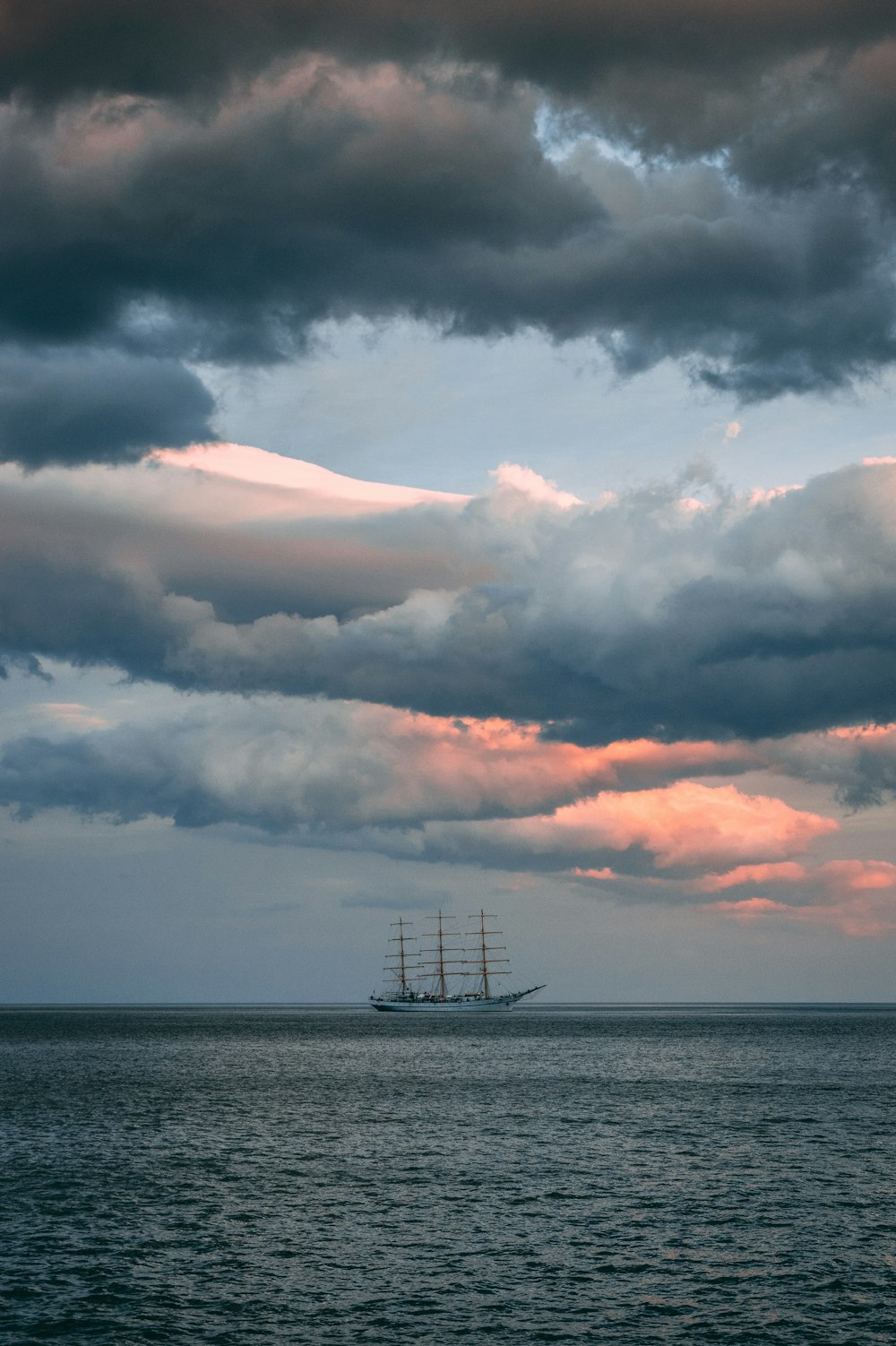 navio branco e marrom na água do oceano sob o céu nublado durante o dia