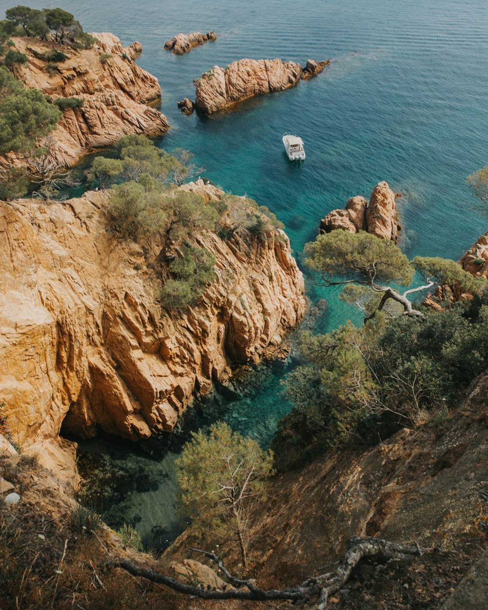 bird's-eye photography of boat near rock formations