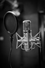 grayscale photo of condenser microphone beside pop filter